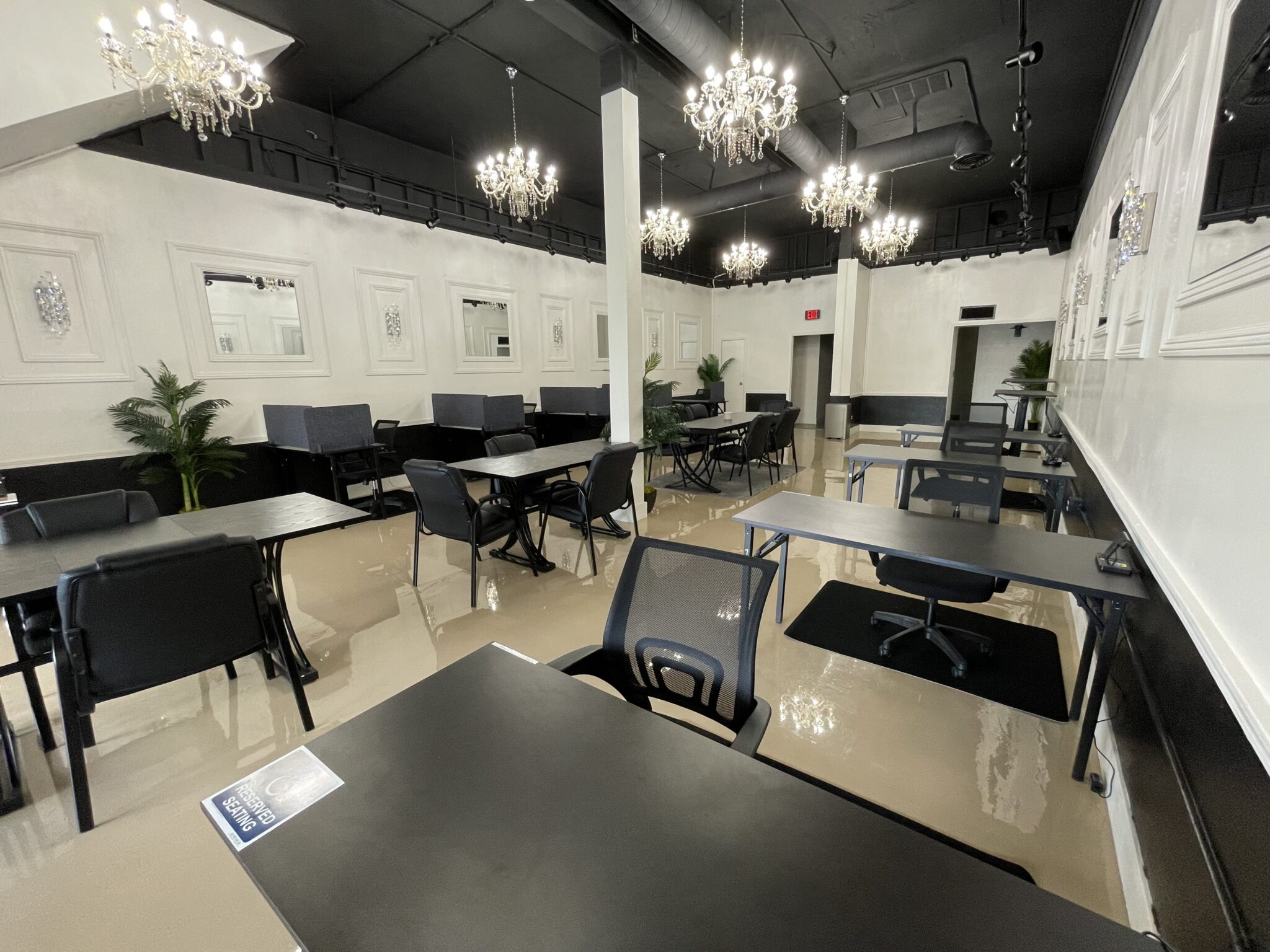 Modern open coworking area with desks, ergonomic office chairs, and natural lighting